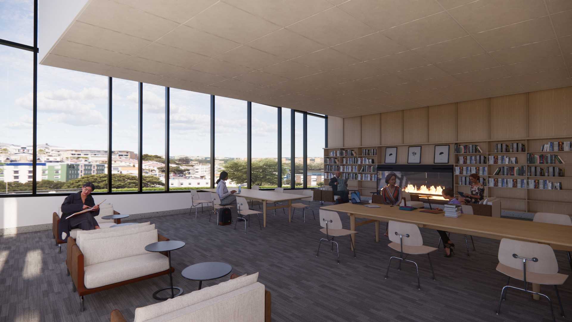 A room with large windows, tables and seating areas for studying, bookshelves in background